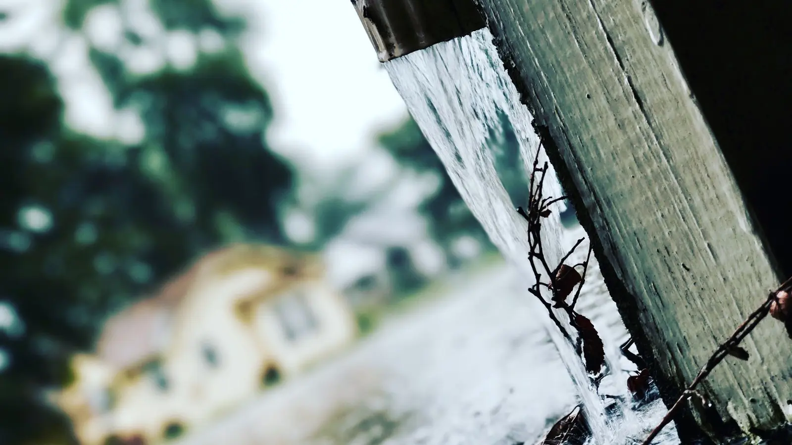 Close-up of rainwater pouring from the end of a gutter
