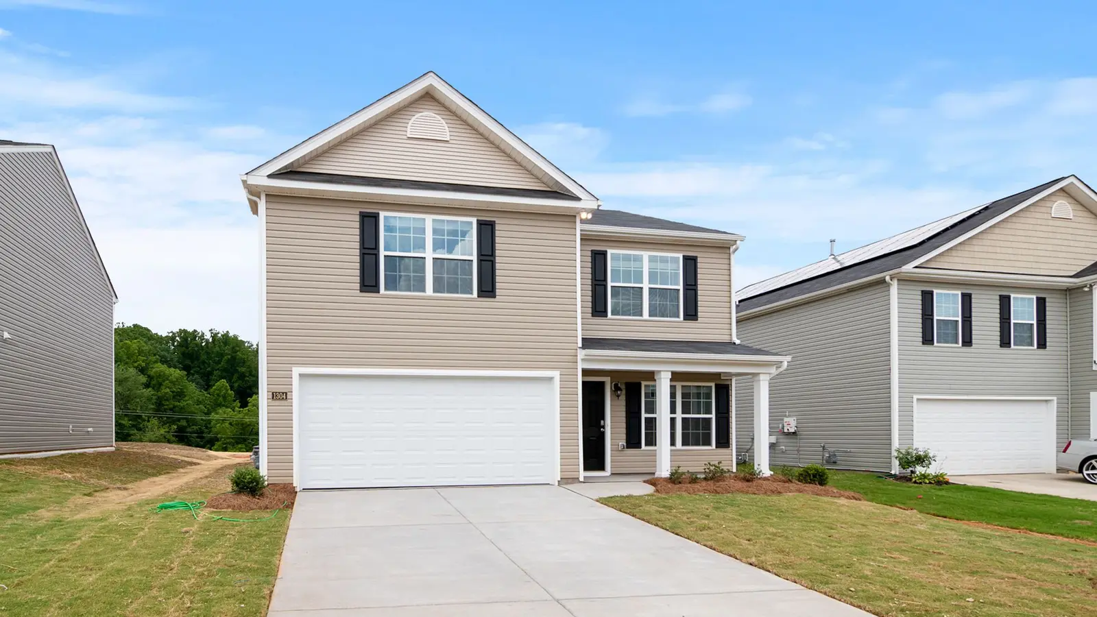 Two-story house with a two-car garage, new lawn and concrete driveway